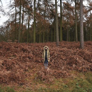 Woman standing in an forrest autumn park trees