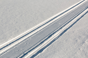Snowmobile trail on white snow