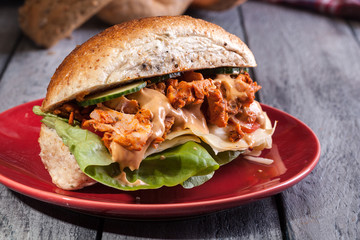Fried chicken meat with cheese and vegetables in bun