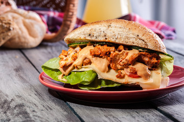 Fried chicken meat with cheese and vegetables in bun