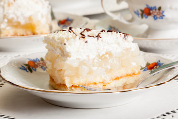 Fresh sweet apple cake with whipped cream served with cup of tea