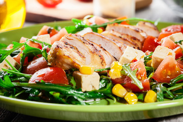 Fresh salad with chicken breast, arugula and tomato