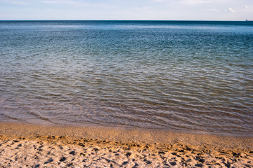 Seashore with sky. Water with sand. Great place for summer vacation. Swim and surf.