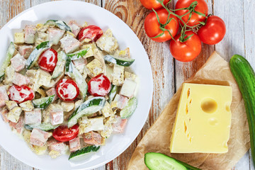 salad with meat, cucumber, tomato, cheese, omelette