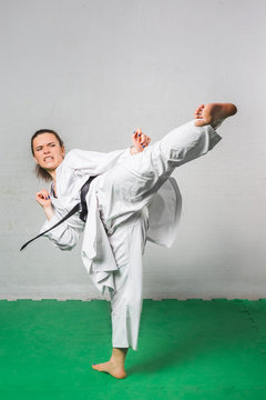 Young Woman Practicing with Kicks in Karate Martial Art