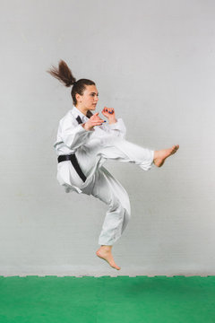 Young Woman Practicing with Kicks in Karate Martial Art