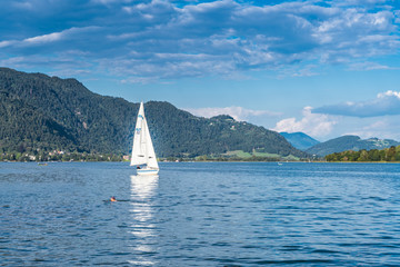 Segelboot und Badegast am Ossiacher See in K&auml;rnten &Ouml;sterreich