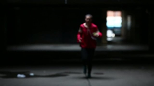 Young woman running in underground building garage.