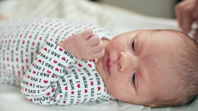 Mother Cleaning Face of Newborn Baby Hands
