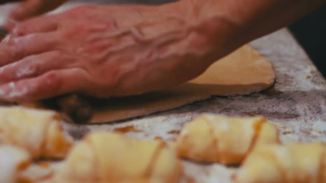 Woman working with dough. making homemade croissants