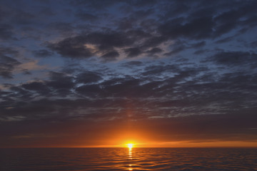 sunset at the sea with cloudy sky