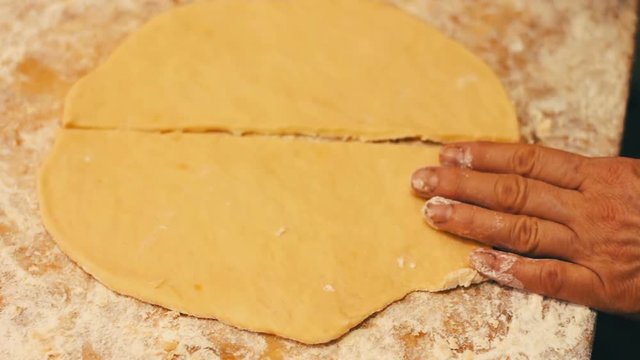 Woman cutting dough with a knife