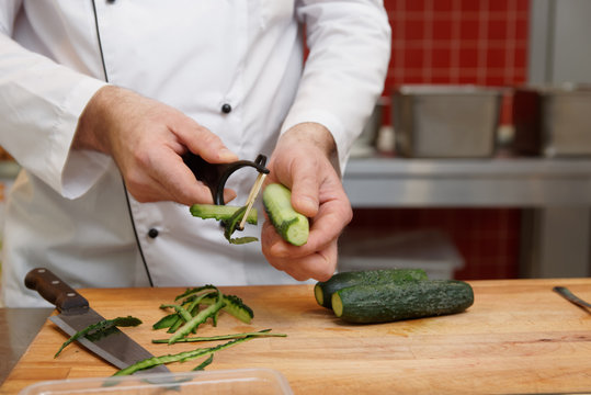 Chef is peeling cucumbers