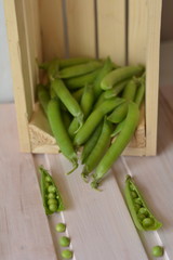 Open, ripe, green, fresh pea pod on foreground 