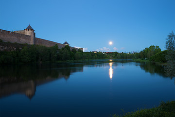 Fototapeta na wymiar August twilight at the walls of the Ivangorod fortress. Border river Narva, Russia