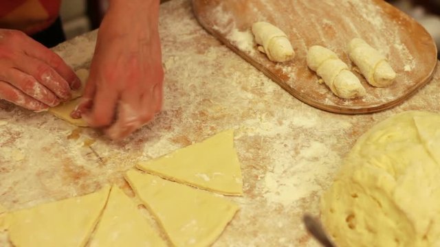 Woman working with dough. making homemade croissants