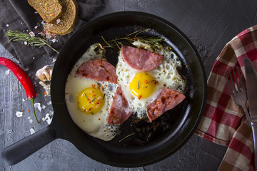 fried eggs iron frying pan rosemary spice pepper

