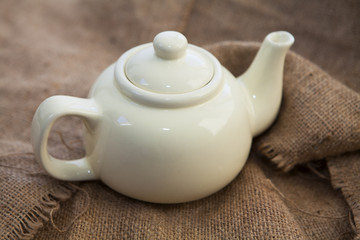 théière en céramique beige sur toile de jute