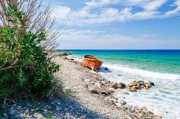 Abandoned orange boat at the beach Platanaki on the aegean island Samos