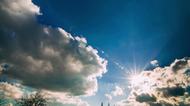White clouds and sun running over blue sky