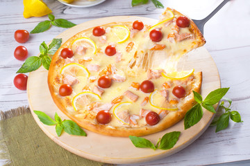 Pizza with seafood red fish, salmon, shrimp, tomatoes, still life, cheese, stretches, shoulder, slice, rises