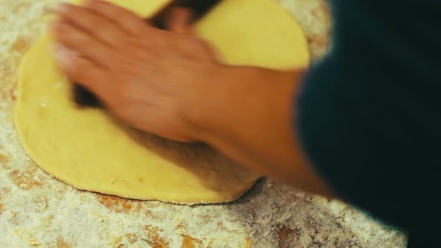 Woman cutting dough with a knife