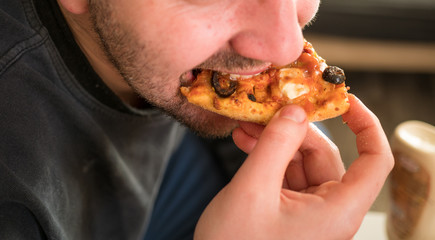 Man eating a slice of pizza