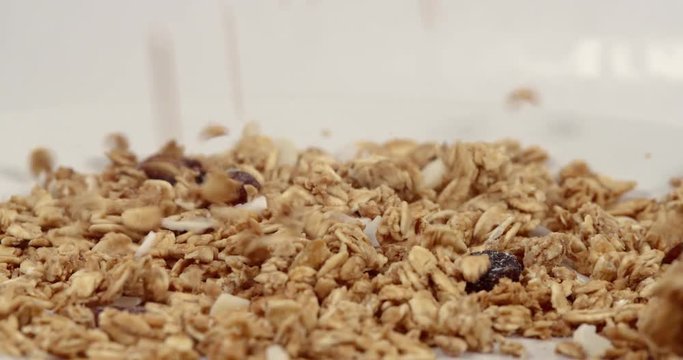 Cereal nuts and grains falling in slow motion into clean bowl
