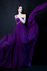 Naklejka premium Fashion Woman in violet dress with Magic Makeup and Hairstyle
