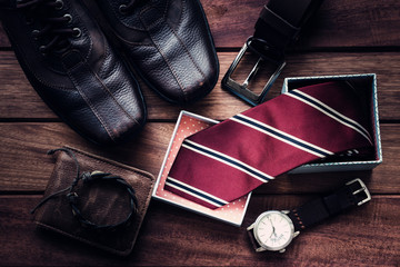 Still life with Men's casual outfits with leather accessories on brown wooden background, beauty...