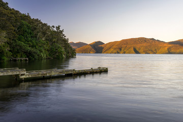 Obraz premium Sunset over the lake with wooden pier.