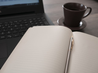 Open notebook with laptop and coffee, working concept