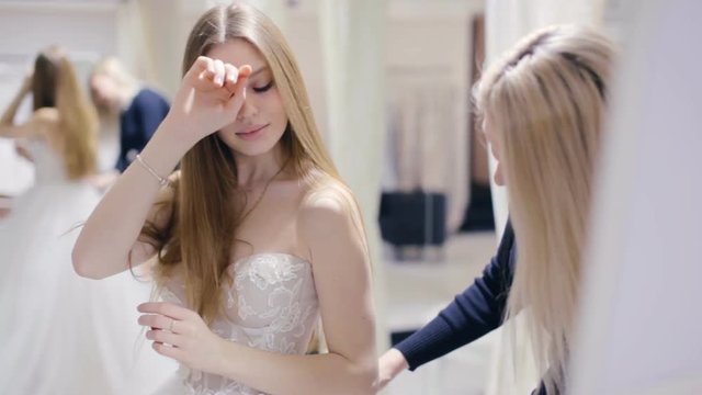 Young woman chooses a wedding dress in bridal shop