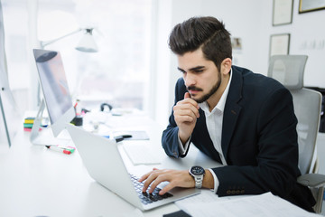 Fototapeta premium Professional businessman working on laptop in office