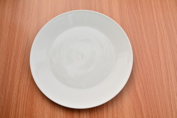 Empty plate on wood table background. View from above