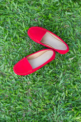 Red shoes girl on green grass