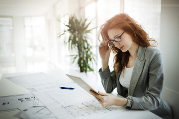 Beautiful female architect working on plan