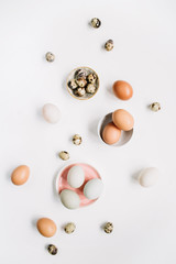 White and brown Easter eggs and quail eggs on white background. Flat lay, top view. Traditional spring concept.