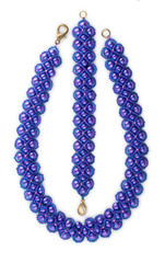 Fashionable homemade jewelry made of dark purple beads. Necklace and bracelet isolated on white background. Top view, close-up.