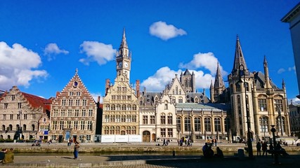 Obraz premium Ghent medieval city, View of Graslei, Korenlei Streets, Korenmarkt, Post Office, Clock Tower over Leie river. Ghent, Belgium.