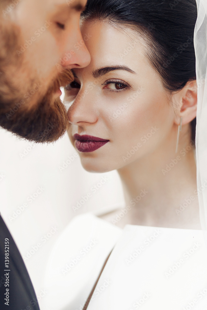 Wall mural elegant gorgeous bride gently and stylish groom portraits, posing in light. unusual wedding couple in retro style. romantic moment