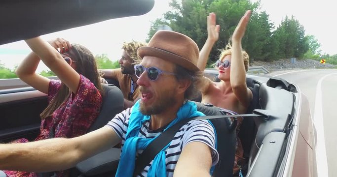 Bearded hipster man with a hat driving his friends in convertible