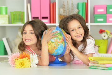 Obraz na płótnie Canvas Two cute girls embracing Globe
