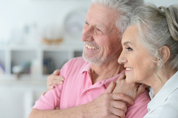 Happy elderly couple standing embracing