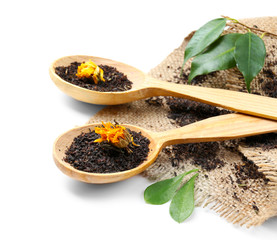 Black tea in wooden spoons isolated on white