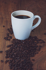 cup of coffee and coffee beans with a film filter