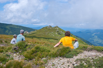 Fototapeta premium Hiker, man sitting on an alpine meadow next to his friends