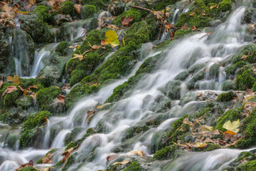 Fototapeta na wymiar Cascadas de agua entre piedras con musgo