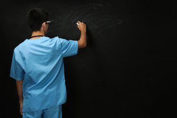 Young handsome medical student on blackboard background