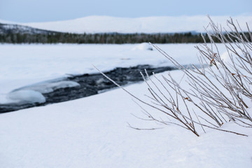 Winter landscape with unfrozen river in Russian Lapland, Kola Peninsula